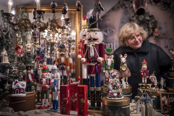 خانمی در بازار کریسمس در میدان &quot;کلیسای جامع&quot; در ویلنیوس، لیتوانی اسباب بازی می فروشد. - اسپوتنیک ایران  