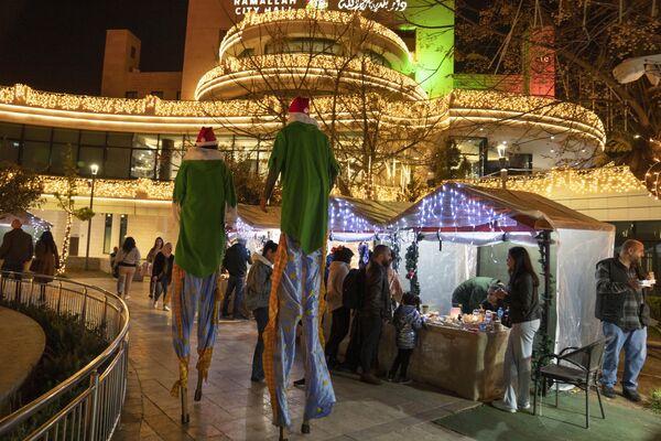  فلسطینی ها در حین خرید هدایا در بازار سنتی کریسمس  در شهر رام الله در کرانه باختری  هستند.   - اسپوتنیک ایران  