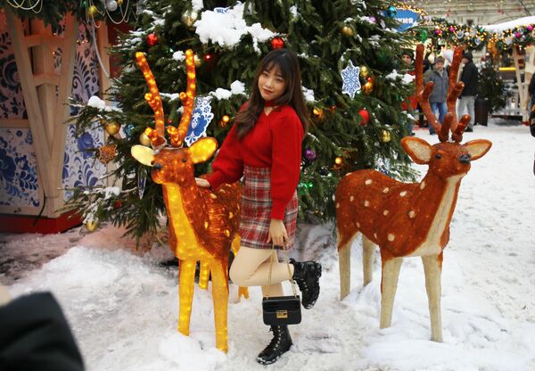 دختری  با تزیینات بازار کریسمس در مرکز تجاری گوم در&quot; میدان سرخ&quot;، مسکو عکس می گیرد. - اسپوتنیک ایران  