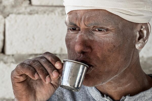 یک کارگر در روز 7 دسامبر 2019 در محل معدن سنگ آهک &quot;کوه سفید&quot; در نزدیکی شهر جنوبی مصر، منیا، در 265 کیلومتری جنوب پایتخت، یک فنجان چای می نوشد. - اسپوتنیک ایران  