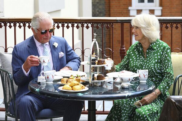 شاهزاده چارلز بریتانیا و کامیلا، دوشس کورنوال، در طی بازدید از تئاتر رویال دروری لین، مرکز لندن، چهارشنبه 23 ژوئن 2021، چای عصرانه را در تراس می نوشند. - اسپوتنیک ایران  