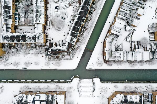 نمای هوایی از پشت بام خانه ها و جاده ها را پوشانده و کانالی در واپینگ در شرق لندن که پوشیده از برف هستند12 دسامبر 2022 - اسپوتنیک ایران  