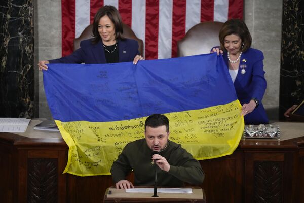 کامالا هریس، معاون رئیس‌جمهور و نانسی پلوسی، رئیس مجلس نمایندگان آمریکا، در حال نشان دادن پرچم اوکراین که به امضای سربازان خط مقدم این کشور رسیده است. در جریان سخنرانی زلنسکی در کنگره آمریکا21 دسامبر 2022 - اسپوتنیک ایران  