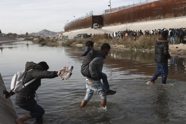 عبور مهاجران از ریو گراند به سمت مرز ایالات متحده و مکزیک در سیوداد خوارز، مکزیک20 دسامبر 2022  - اسپوتنیک ایران  