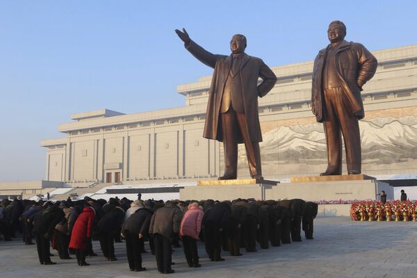 مردم در حال ادای احترام در مقابل مجسمه رهبران سابق کیم ایل سونگ و کیم جونگ ایل به مناسبت یازدهمین سالگرد مرگ کیم جونگ ایل در پیونگ یانگ - اسپوتنیک ایران  