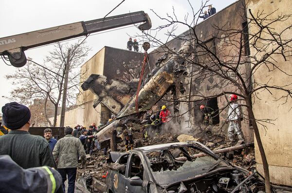 امدادگران در محل سقوط یک فروند هواپیمای آموزشی نیروی هوایی ایران که در یک منطقه مسکونی در شمال غرب شهر تبریز در تاریخ 21 فوریه 2022 سقوط کرده بود - اسپوتنیک ایران  