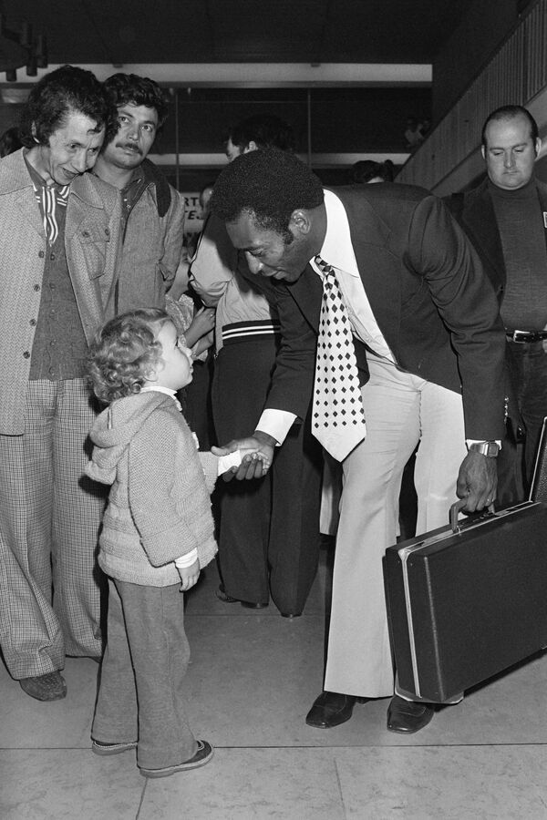 پله بازیکن برزیلی،  در 12 سپتامبر 1976، هنگام ورود به فرودگاه اورلی، همراه با تیم خود- نیویورک کاسموس- برای برگزاری یک بازی دوستانه مقابل پاری سن ژرمن، در تاریخ 15 سپتامبر 1976، به یک کودک دست می دهد. - اسپوتنیک ایران  