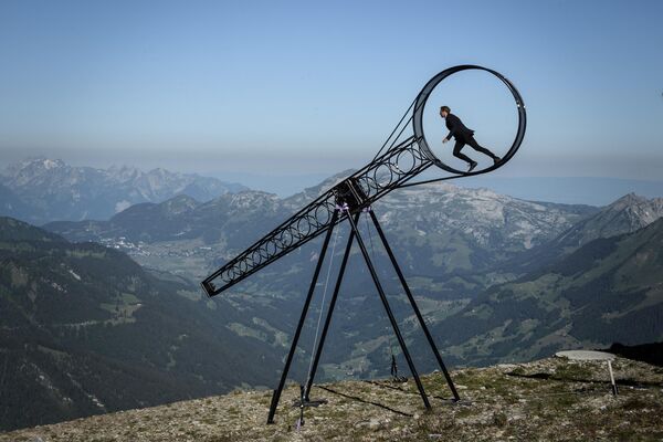 مانند یک برنده خود را حس کنید. در عکس: رامون کاترینر آکروبات سوئیسی در حین اجرای خود در &quot;چرخ مرگ&quot; در یک نمایش هوایی در مجاورت کوهی در سوئیس. - اسپوتنیک ایران  
