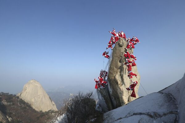 کوه ها درباره ماجراجویی هستند، عشق بزرگ به زندگی و ایمان به بهترین ها. در عکس: کوهنوردان با لباس بابا نوئل در کوه باخان در سئول، کره جنوبی. - اسپوتنیک ایران  