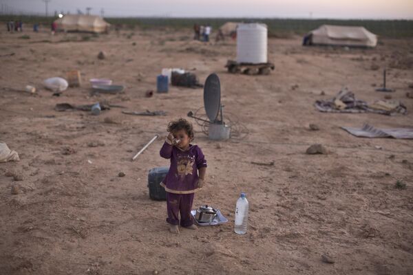 یک دختر سوری در بیرون از چادر خانواده اش در چادر نشینی در نزدیکی مرز سوریه در حومه مفراق، اردن، چای می نوشد. - اسپوتنیک ایران  