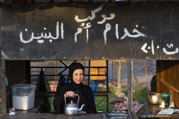 سنت چای در عراق، دستفروشان چای دم شده را به همراه لیوان، شکر با خود حمل می کنند. آنها همه جا هستند - در بازارها، در ایستگاه های اتوبوس، در مؤسسات. در عکس: دختری به زائران مسلمان عراقی در حال عبور چای می دهد. - اسپوتنیک ایران  