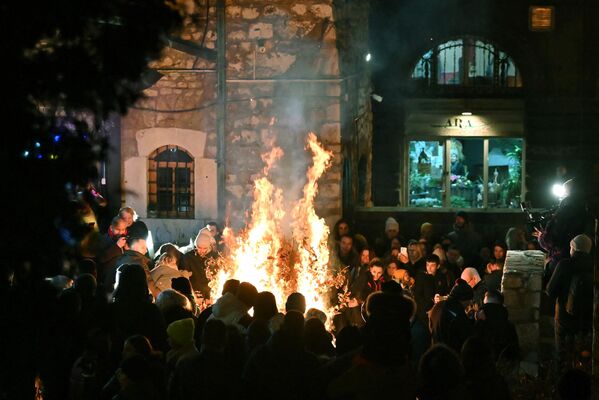 مردم  درمراسم سالانه سوزاندن شاخه‌های خشک درخت بلوط به مناسبت شب کریسمس ارتدکس ها در کلیسایی در شهر سارایوو - اسپوتنیک ایران  