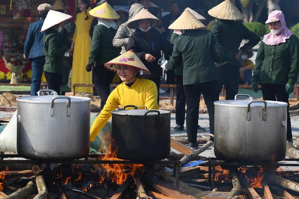 دیگ‌های در حال جوش پر از &quot;Banh Chung&quot; یا کیک‌های برنج سنتی ویتنامی در بتکده Tam Chuc در استان Ha Nam قبل از جشن سال نو قمری یا تت  که تهیه این خوراکی سال نو 10 ساعت طول می کشد. - اسپوتنیک ایران  