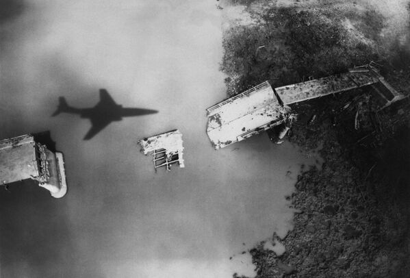 تصویری که در آوریل 1965 از هواپیمای شناسایی آمریکا در حال پرواز بر فراز پل تخریب شده &quot;مودیو&quot; در ویتنام شمالی گرفته شده است - اسپوتنیک ایران  