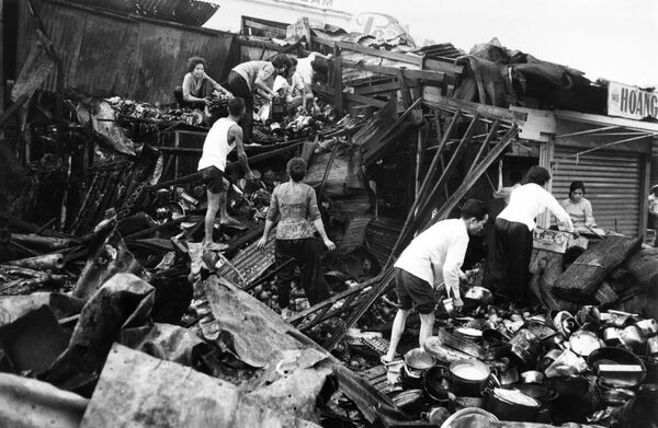مردم در مارس 1969، پس از گلوله باران های خمپاره ای ویت کنگ ها در نزدیکی بازار مرکزی سایگون، وسایل خود را از زیر آوار مغازه ها جمع می کنند - اسپوتنیک ایران  