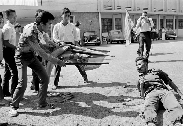 دانشجویان ویتنام جنوبی یک سربازارتش  دولتی را که مورد ضرب و شتم قرار گرفته تهدید می کنند. - اسپوتنیک ایران  