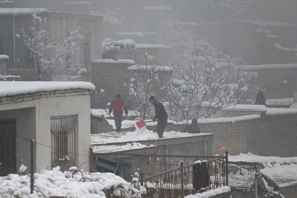 ساکنان کابل در هنگام برف روبی پشت بام خانه ها11 ژانویه 2023 - اسپوتنیک ایران  