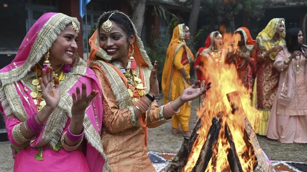 Студенты исполняют пенджабский народный танец Гиддха вокруг костра во время празднования фестиваля Лори в Амритсаре, Индия - اسپوتنیک ایران  