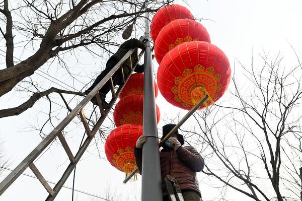آویزان کردن فانوس های قرمز سال نو در پکن. - اسپوتنیک ایران  