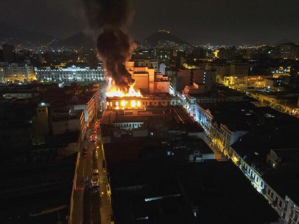  یک ساختمان در جریان تظاهرات ضد دولتی در مرکز شهر لیما، پرو، روز پنجشنبه، 19 ژانویه 2023 در آتش می سوزد. - اسپوتنیک ایران  