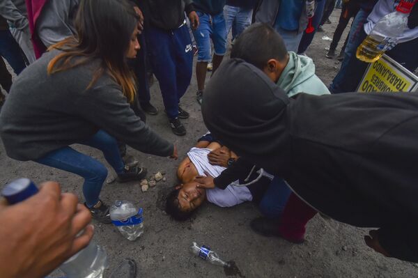 مردم به مردی که در جریان تظاهرات ضد دولتی در آرکیپا، پرو، روز پنج‌شنبه، 19 ژانویه 2023 مجروح شده، کمک می‌کنند. - اسپوتنیک ایران  