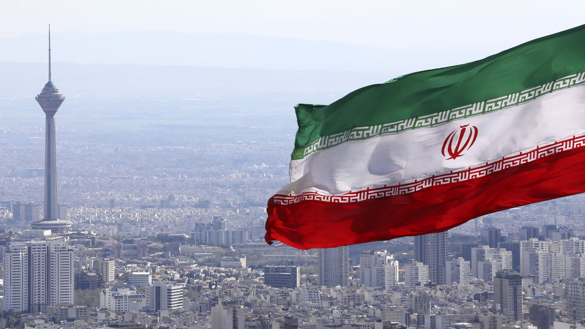  In this March 31, 2020, file photo, Iran's national flag waves as Milad telecommunications tower and buildings are seen in Tehran, Iran - اسپوتنیک ایران  , 1920, 21.01.2023