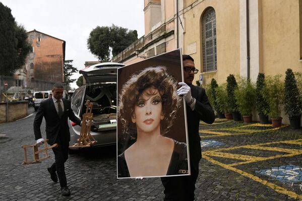 یک کارمند سرویس تشییع جنازه، عکسی از جینا لولوبریجیدا، اسطوره فقید سینمای ایتالیا، را پیش از تدفین او در کاپیتول هیل رم در روز چهارشنبه، 18 ژانویه 2023، به همراه دارد. لولوبریجیدا که در دهه 1950 به یک ستاره بین المللی تبدیل شد  و به او پس از یکی از فیلم های او لقب &quot;زیباترین زن در جهان&quot; داده شد.  وی در روز دوشنبه 16 ژانویه 2023 در رم درگذشت. او 95 ساله بود.  (AP عکس از /Alessandra Tarantino) - اسپوتنیک ایران  