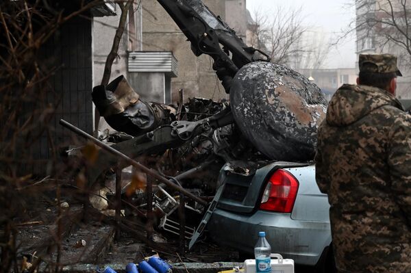 یک نیروی ارتش در محل سقوط یک هلیکوپتر در نزدیکی یک مهدکودک در حاشیه کیف پایتخت اوکراین ایستاده است. در این حادثه در 18 ژانویه 2023  شانزده نفر از جمله دو کودک و وزیر کشور اوکراین  کشته شدند. - اسپوتنیک ایران  