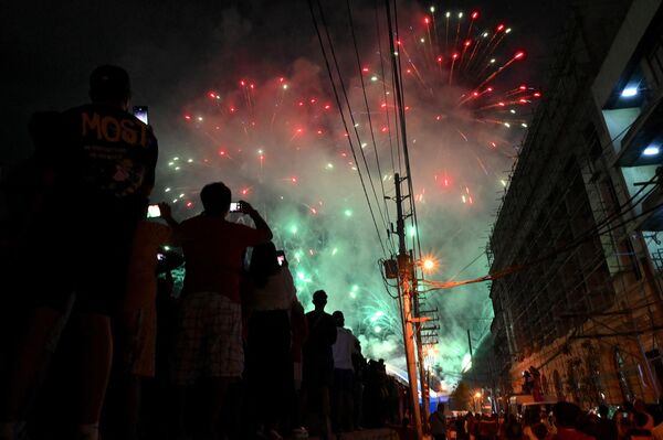 آتش بازی ها بر فراز پل Binondo-Intramuros زمانی که مردم با شادی سال نو قمری را در مانیل در 22 ژانویه 2023 جشن می گیرند. - اسپوتنیک ایران  