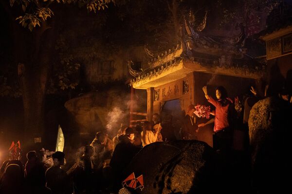 مردم هنگام قدم زدن در اطراف معبد A-Ma هنگام شروع جشن های سال نو قمری چینی در ماکائو در 21 ژانویه 2023، چوب های بخور به دست می گیرند. - اسپوتنیک ایران  