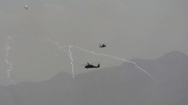 Anti-missile decoy flares are deployed as U.S. Black Hawk military helicopters and a dirigible balloon fly over the city of Kabul, Afghanistan, Sunday, Aug. 15, 2021. - اسپوتنیک ایران  