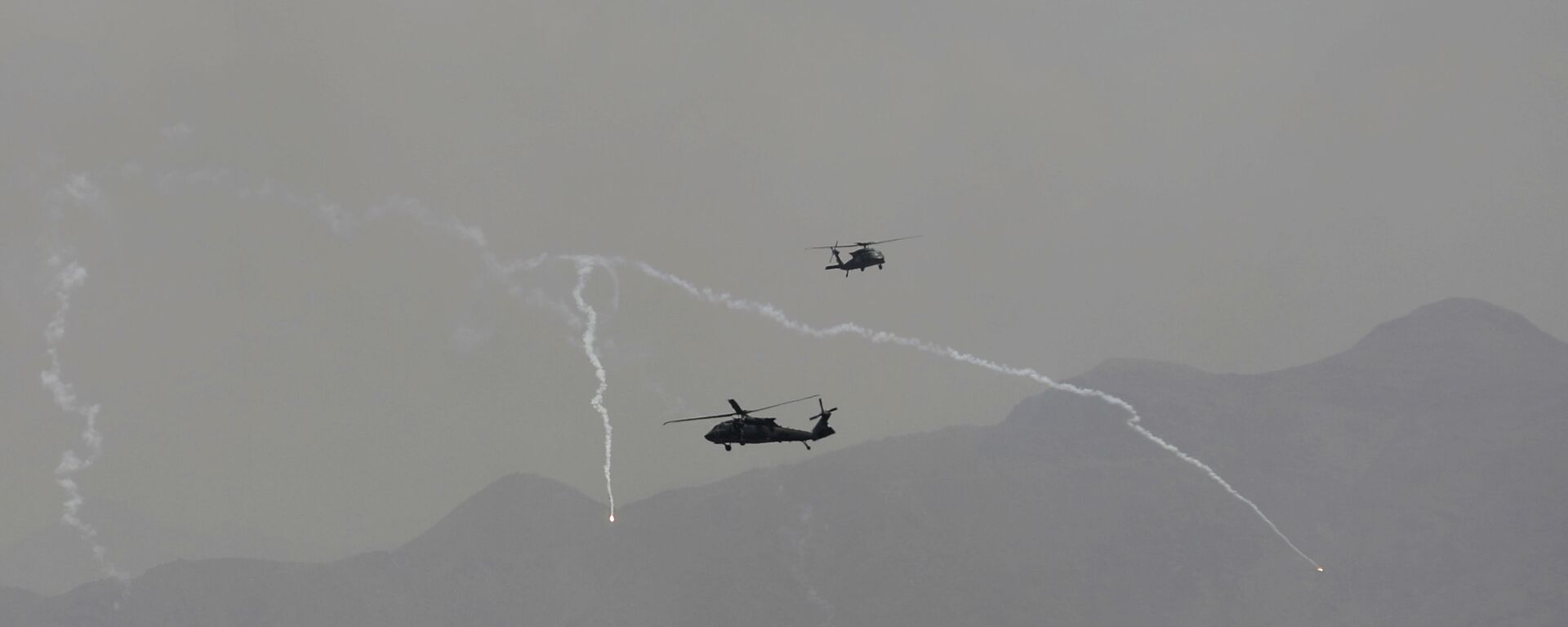 Anti-missile decoy flares are deployed as U.S. Black Hawk military helicopters and a dirigible balloon fly over the city of Kabul, Afghanistan, Sunday, Aug. 15, 2021. - اسپوتنیک ایران  , 1920, 25.01.2023