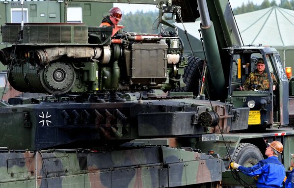 سربازان نیروی مسلح المان یک تانک رزمی لئوپارد 2  را در یک اردوگاه در طی تمرین آموزشی &quot;تمرین عملیات زمینی 2017&quot; در منطقه آموزش نظامی در مونستر واقع در شمال آلمان، در تاریخ 13 اکتبر 2017 تعمیر می کنند. (عکس از PATRIK STOLLARZ / AFP) - اسپوتنیک ایران  