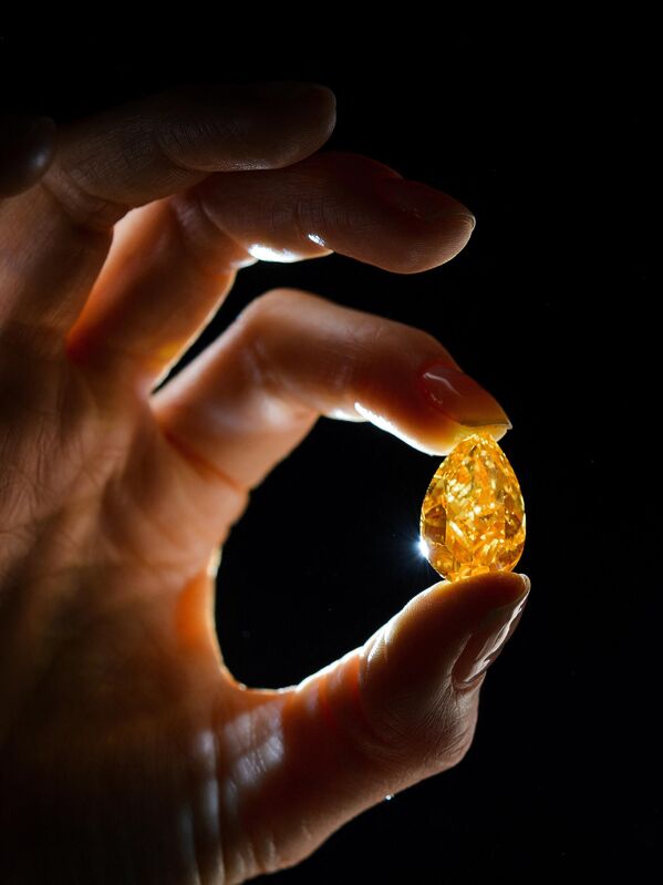 یک الماس گلابی شکل 14.82 قیراطی و پرتقالی زنده در یک پیش نمایش مطبوعاتی در 31 اکتبر 2013 در ژنو.بزرگترین الماس نارنجی شناخته شده در جهان توسط کریستیز در شهر ژنو سوئیس به حراج گذاشته شد و انتظار می رود بین 12.5 تا 15 میلیون یورو (17 تا 20 میلیون دلار آمریکا) به فروش برسد. - اسپوتنیک ایران  