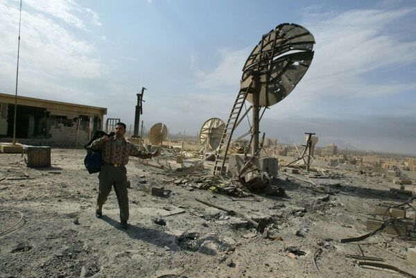 یک کارمند وزارت اطلاعات عراق در 29 مارس 2003 پس از اصابت موشک نیروهای ائتلاف، بین ظروف شکسته روی پشت بام ساختمان این وزارتخانه در بغداد راه می رود. موج حملات به پایتخت عراق و اطراف آن امروز در دهمین روز از جنگ ادامه یافت و پس از کشته شدن تعداد زیادی از مردم در یک بازار، حداقل یک موشک به سمت وزارت اطلاعات اصابت کرد. AFP PHOTO/Patrick BAZ (عکس از PATRICK BAZ / AFP) - اسپوتنیک ایران  