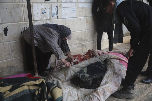 تلاش یک زن برای شناسایی اجساد قربانیان زلزله در شهر ازمارین در استان ادلب در شمال سوریه. - اسپوتنیک ایران  