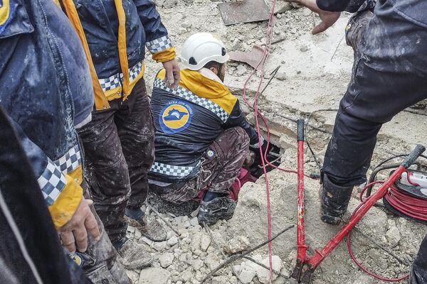 اعضای دفاع مدنی سوریه در جستجوی افراد زیر آوار یک ساختمان ویران شده بر اثر زلزله 6 فوریه در عفرین سوریه هستند. - اسپوتنیک ایران  