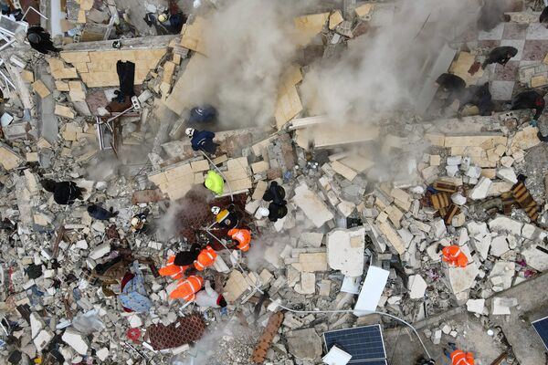 این نمای هوایی ساکنانی را نشان می‌دهد که با کمک بولدوزر در حال جستجوی قربانیان و بازماندگان در زیر آوار ساختمان‌های فروریخته، پس از زلزله در شهر سرمده در حومه شمال غربی استان ادلب سوریه، در اوایل 6 فوریه 2023 هستند.زمین لرزه ای به بزرگی 7.8 ریشتر در 6 فوریه ترکیه و سوریه را لرزاند و صدها نفر را هنگام خواب کشته، ساختمان ها را تسطیح کرد و لرزش هایی را که تا جزیره قبرس و مصر احساس شد، فرستاد. - اسپوتنیک ایران  
