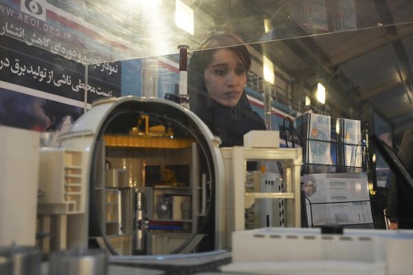  دانشجویی به مدلی از نیروگاه اتمی بوشهر در نمایشگاه دستاوردهای هسته ای ایران در تهران، روز چهارشنبه 8 فوریه 2023 نگاه می کند. - اسپوتنیک ایران  