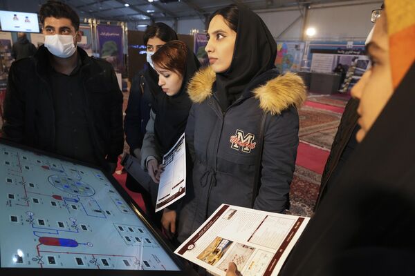 دانشجویان هنگام بازدید از نمایشگاه دستاوردهای هسته ای ایران در تهران، روز چهارشنبه 8 فوریه 2023 به سخنان یک کارشناس گوش می دهند. - اسپوتنیک ایران  