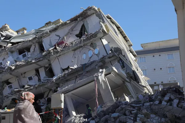 یک زن پنج روز پس از زلزله 7.8 ریشتری که منطقه مرزی ترکیه و سوریه را لرزاند، در مقابل یک ساختمان فروریخته در Islahiya، در منطقه آسیب دیده غازیانتپ ایستاده است. - اسپوتنیک ایران  