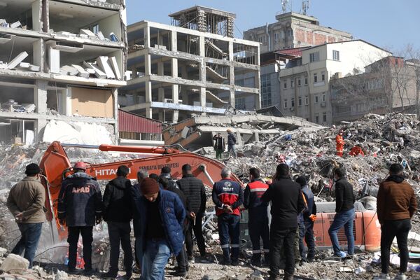 گروه نجات و امداد در حال جستجوی اجسادی که زیر آوار باقی مانده اند. خانه ها بر اثر زمین لرزه مهیب و مخرب در ترکیه فرو ریختند. - اسپوتنیک ایران  