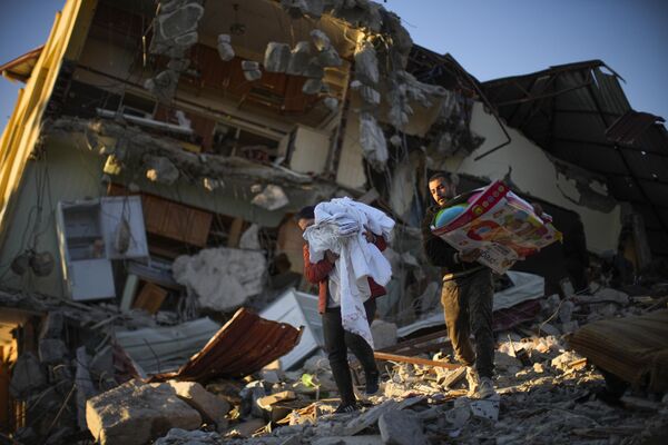 بردن وسایل از خانه ویران بر اثر زمین لرزه در ترکیه. - اسپوتنیک ایران  