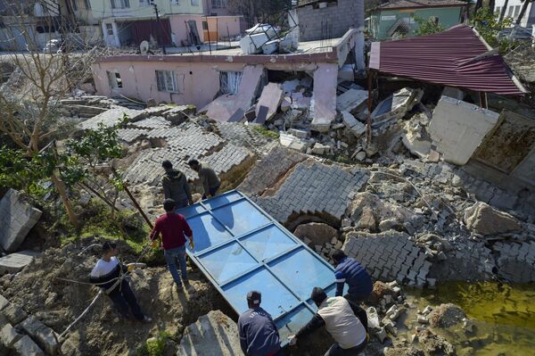 بردن وسایل از خانه ویران بر اثر زمین لرزه در ترکیه. - اسپوتنیک ایران  