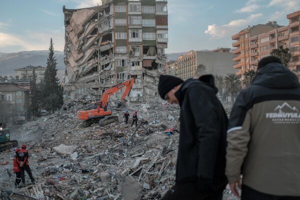 گروه نجات و امداد در حال جستجوی اجسادی که زیر آوار باقی مانده اند. خانه ها بر اثر زمین لرزه مهیب و مخرب در ترکیه فرو ریختند. - اسپوتنیک ایران  