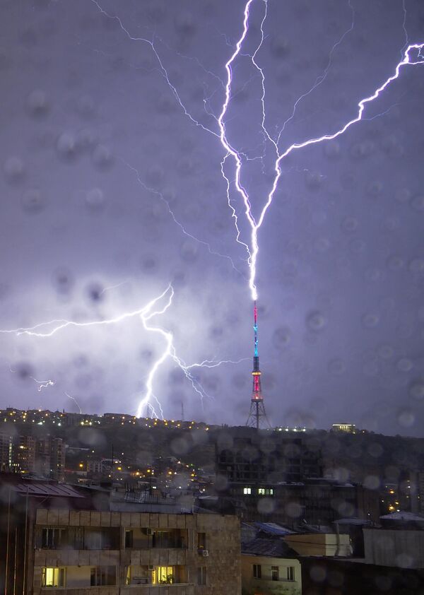 در این عکس که از پنجره ای پوشیده از قطرات باران گرفته شده است، رعد و برق به یک برج تلویزیونی در ایروان، پایتخت ارمنستان برخورد می کند. 10 اکتبر 2020 - اسپوتنیک ایران  
