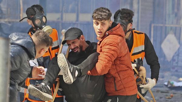 Палестинцы уносят раненого во время израильского рейда в оккупированном городе Наблус  - اسپوتنیک ایران  