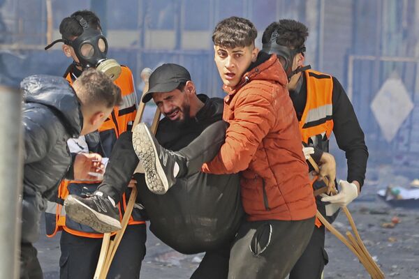 فلسطینی‌ها یک مرد مجروح را در جریان حمله اسرائیل به شهر نابلس کرانه باختری انتقال می دهند. - اسپوتنیک ایران  
