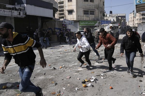 فلسطینی ها در جریان درگیری با نیروهای اسرائیلی در شهر نابلس کرانه باختری روز چهارشنبه در حال فرار هستند. - اسپوتنیک ایران  