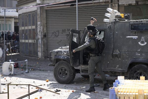 یک افسر شبه نظامی پلیس مرزی اسرائیل در جریان درگیری ها در شهر نابلس کرانه باختری به سوی فلسطینی ها گاز اشک آور پرتاب کرد. - اسپوتنیک ایران  